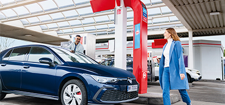 een stel dat hun auto instapt bij een Esso-voorraadstation